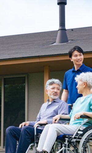elderly couple with caregivers outside care home